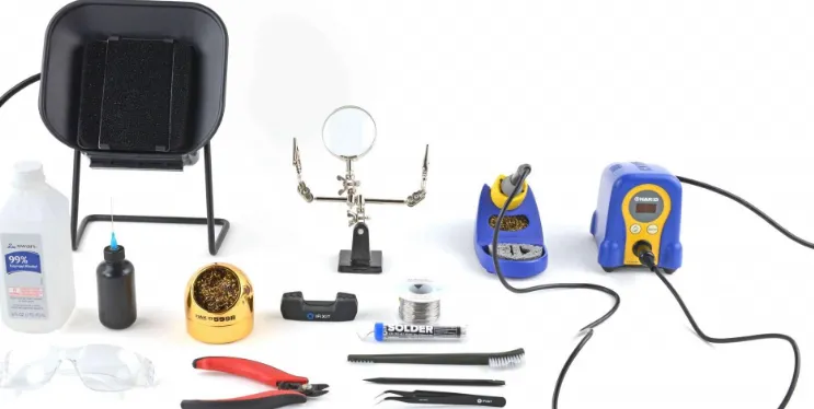 Essential tools for electronics assembly for hobbyists including soldering iron and multimeter