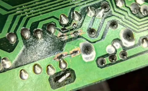 Damaged PCB trace close-up for repair tutorial.