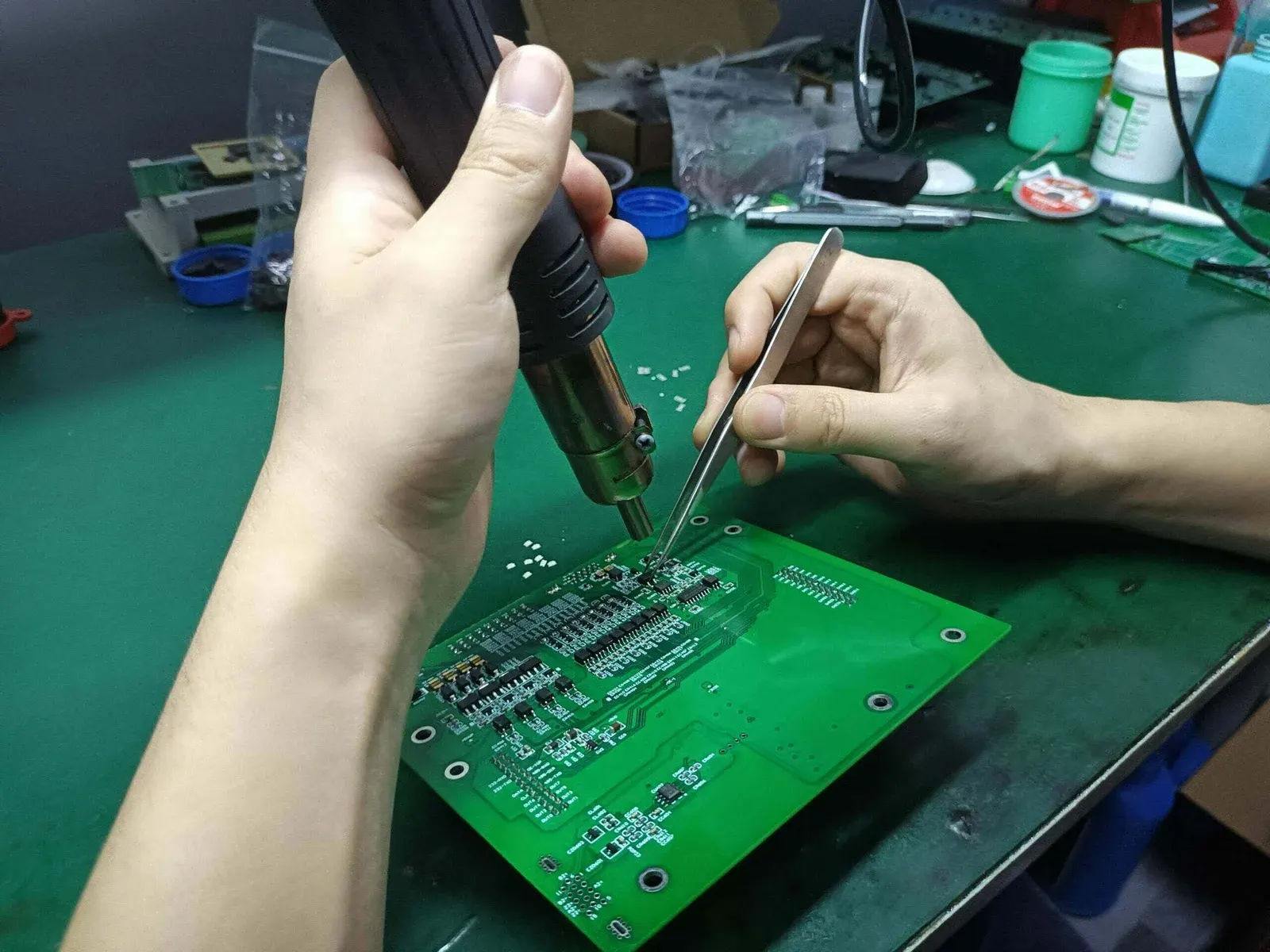 Technician performing solder mask repair on a PCB."