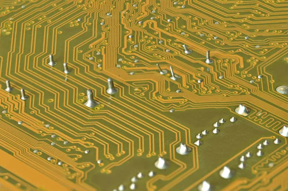 Close-up of flex PCB soldering defects including cold joints and bridges.