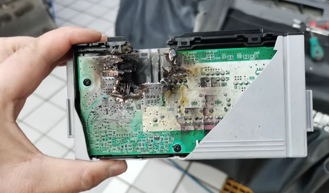 Damaged parking system PCB with burnt components