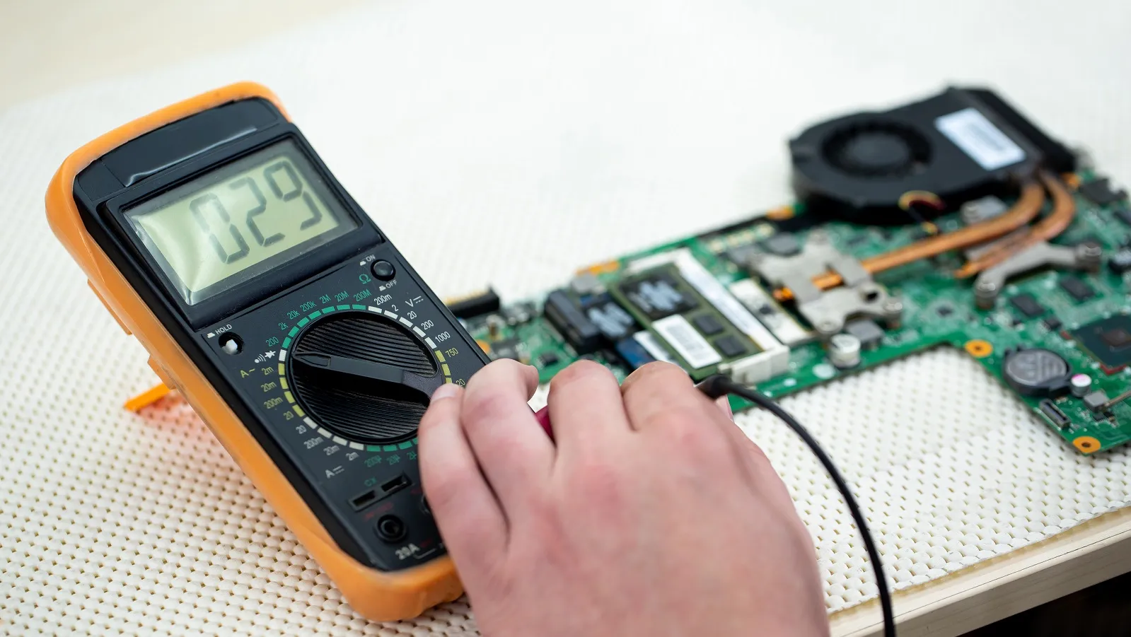 Testing components on a PCB using a multimeter for diagnostics."