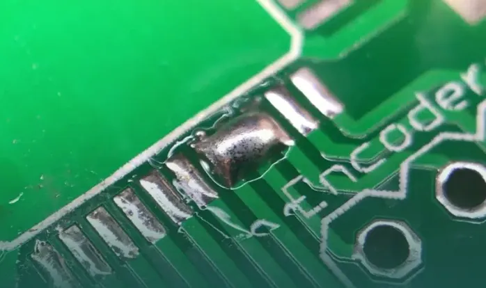 PCB showing solder mask bridging over soldering pads."
