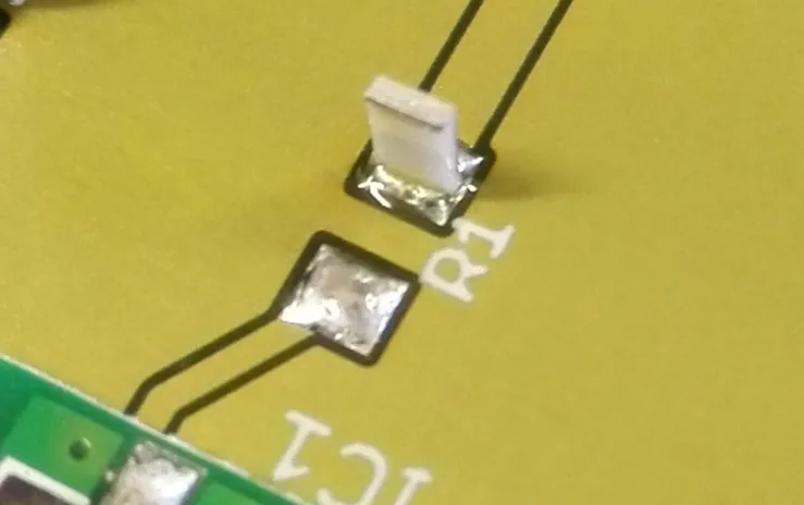 SMT chip capacitor showing tombstoning due to uneven solder paste volume