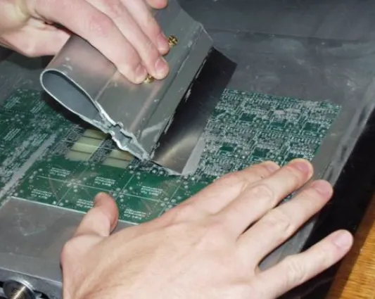 'Engineer applying solder paste via syringe to cleaned PCB pads for component replacement