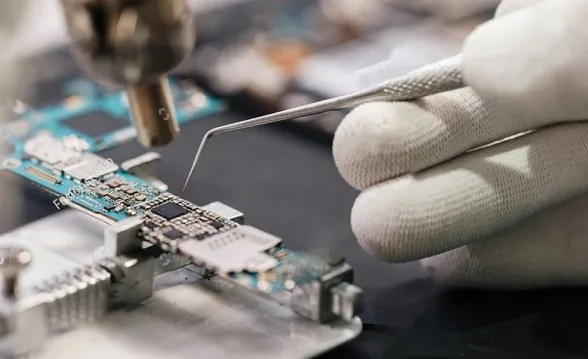 PCB being removed from etching tank during process