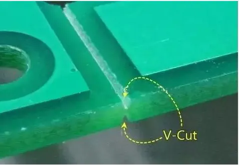 Close-up of V-grooves separating double-sided PCBs in a manufacturing panel