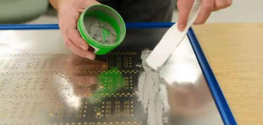 Stencil printer applying SMT solder paste onto PCB pads