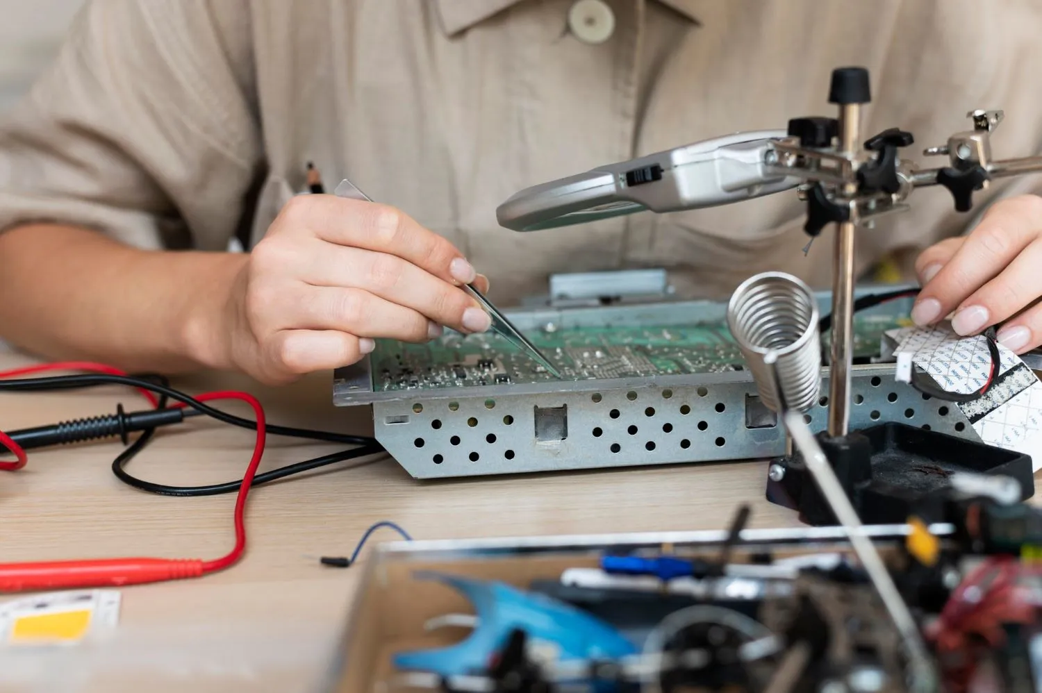 Technician performing HASL rework on a PCB with a soldering iron.