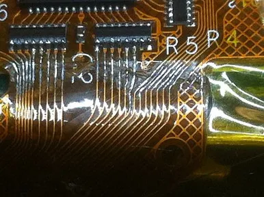 Technician performing rework on a flex PCB with a hot air station.