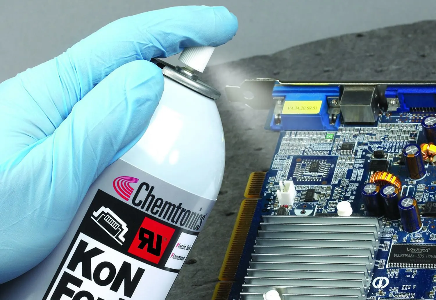 Workspace setup for DIY conformal coating application at home with spray can and tools.