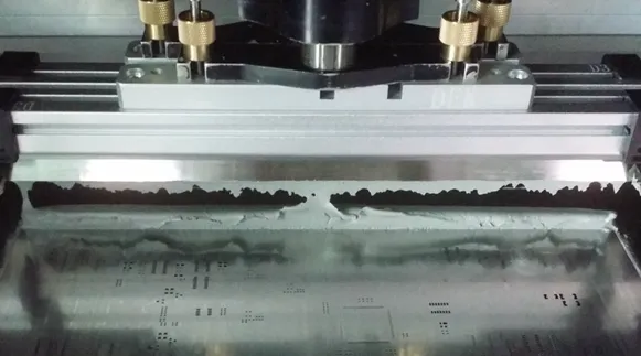 Close-up of stencil printing solder paste onto PCB pads with glossy solder mask