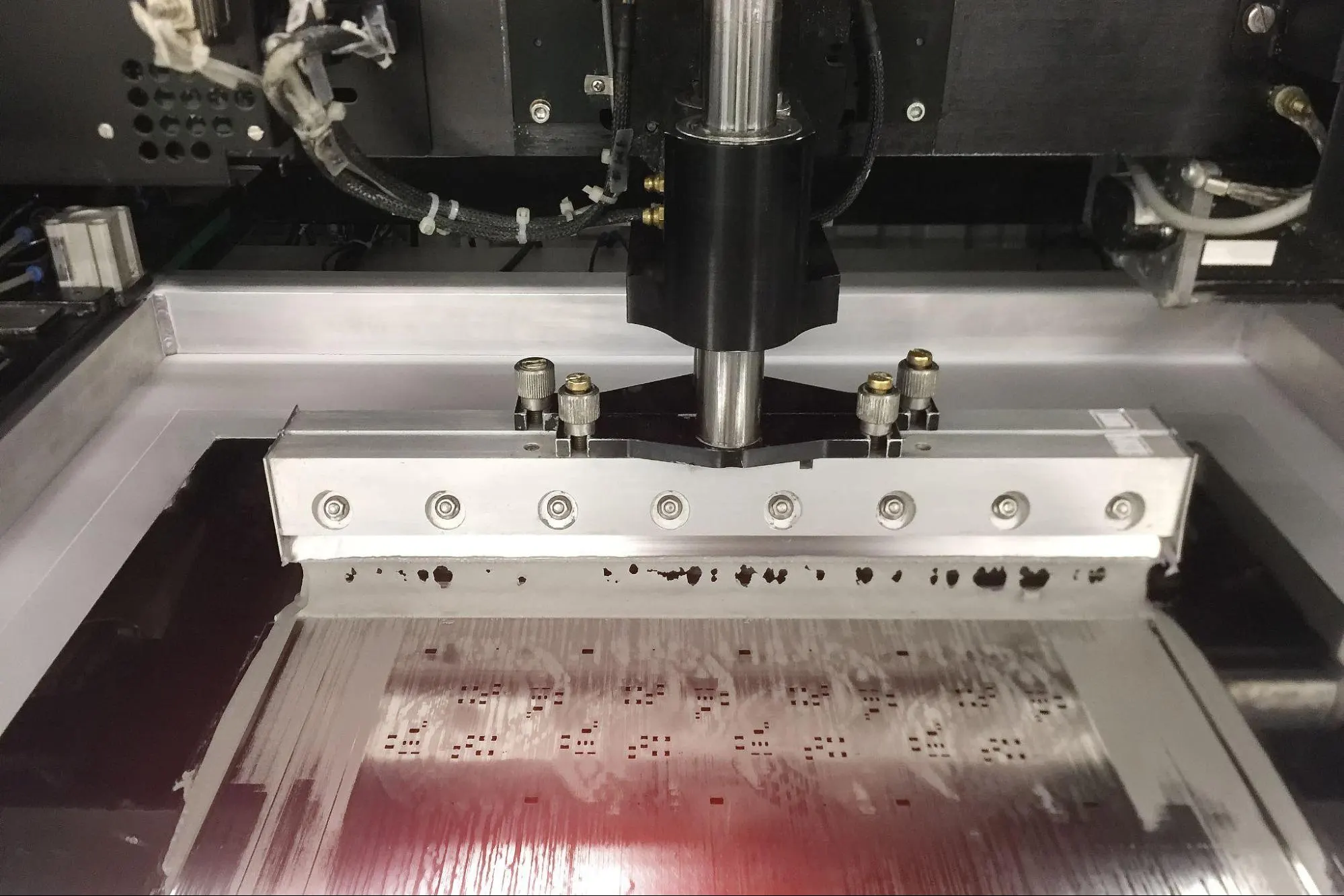 Stencil printer applying solder paste on PCB for SMT assembly