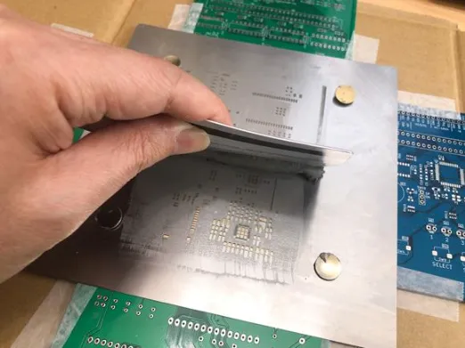 Applying solder paste through mini-stencil aligned on exposed PCB pads