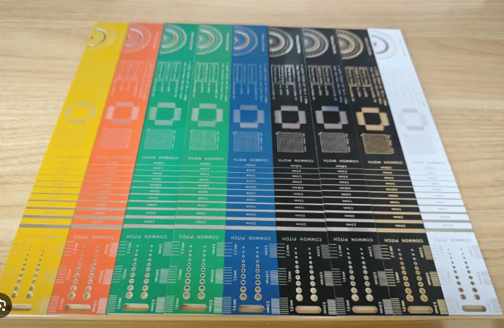 Side-by-side PCBs showing white, black, and yellow silkscreen on different solder masks