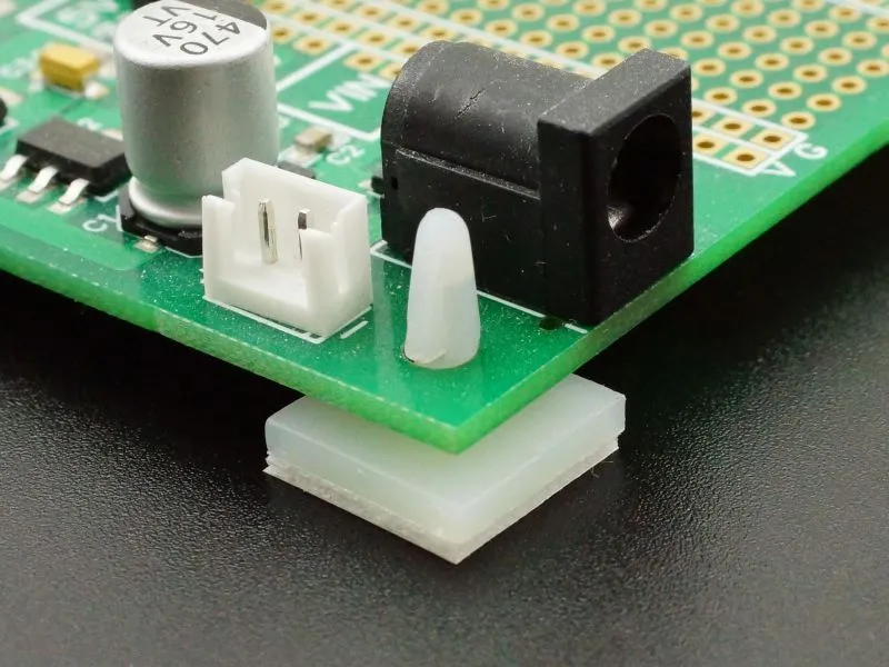 Close-up of PCB mounting hole with screw for grounding and stability.