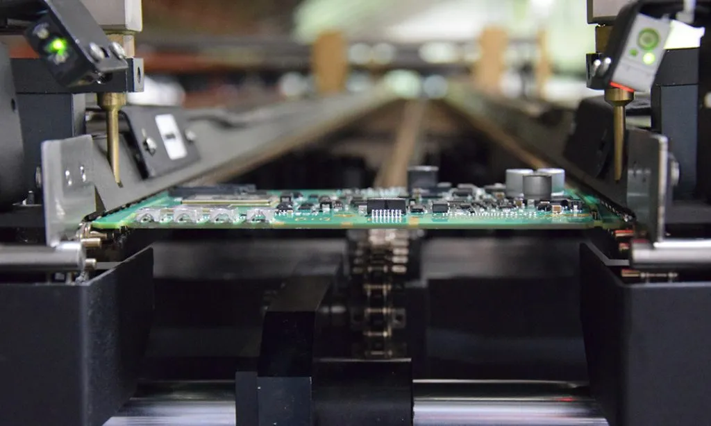 Double-sided PCB undergoing reflow soldering in an oven