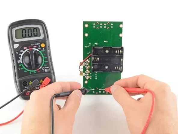 Testing PCB trace continuity with a multimeter.