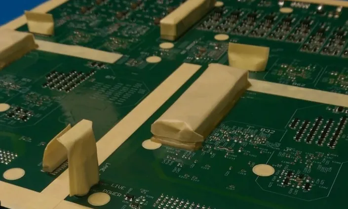 PCB with masking tape on connectors before conformal coating