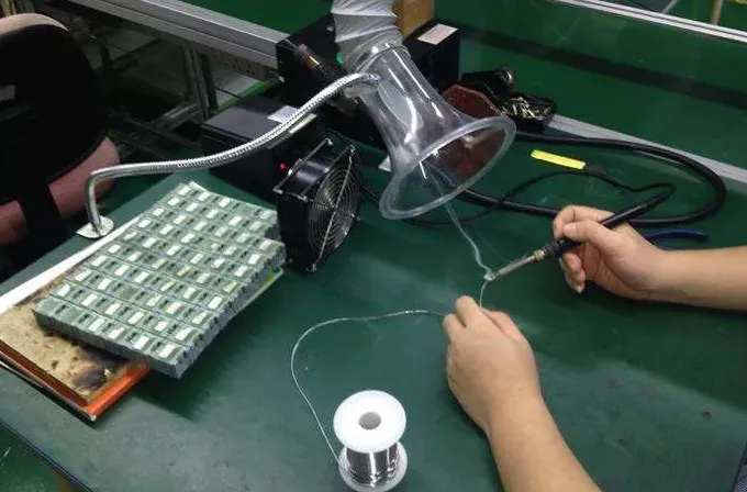Worker soldering with fume extractor for soldering fumes safety