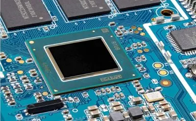 Microcontroller IC on PCB highlighting component cost trends.