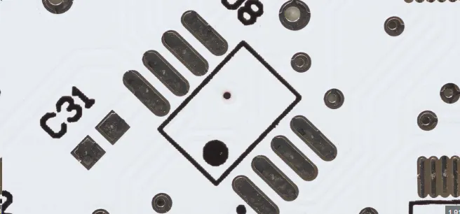 Close-up of black silkscreen text on PCB under bench lighting