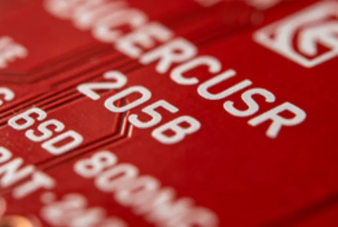 'Close-up view of a red solder mask printed circuit board with white silkscreen markings