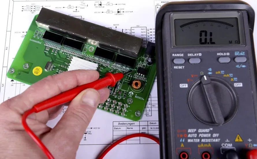 Technician testing SMT assembly continuity with a multimeter.