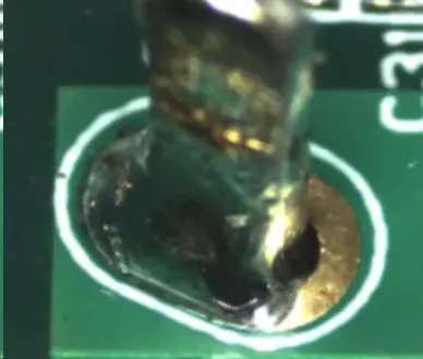 Close-up of PCB with hand soldering defects like solder bridges and cold joints.