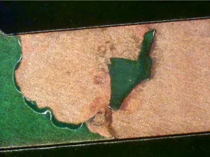 PCB showing LPI solder mask delamination with exposed copper traces."