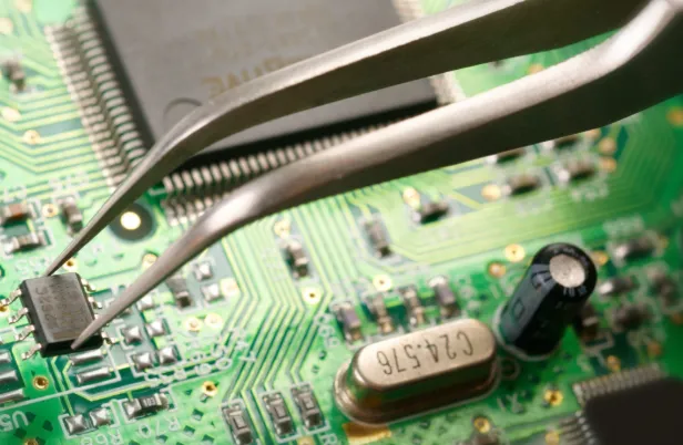 Technician troubleshooting PCB plasma etching equipment"
