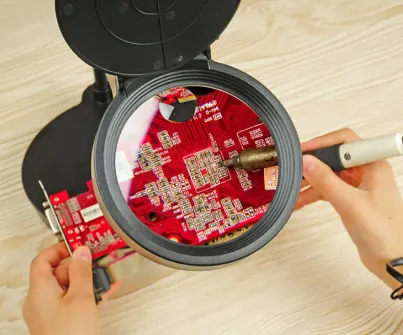 Technician inspecting PCB solder joints with a green solder mask for clarity