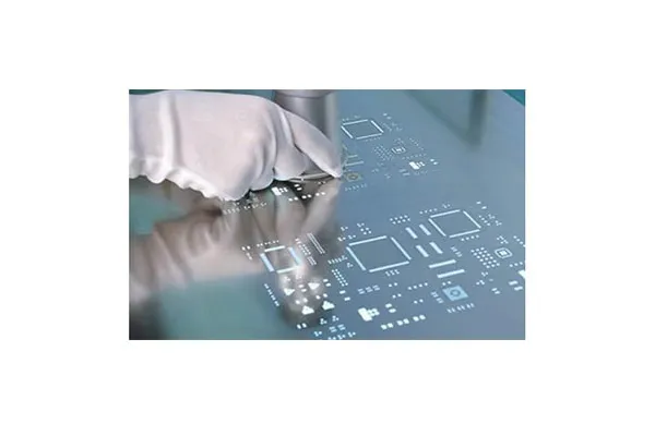 Technician handling PCB stencil with gloves for protection
