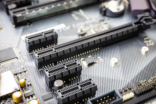 PCB with hard gold plated edge connectors being inserted into a slot.