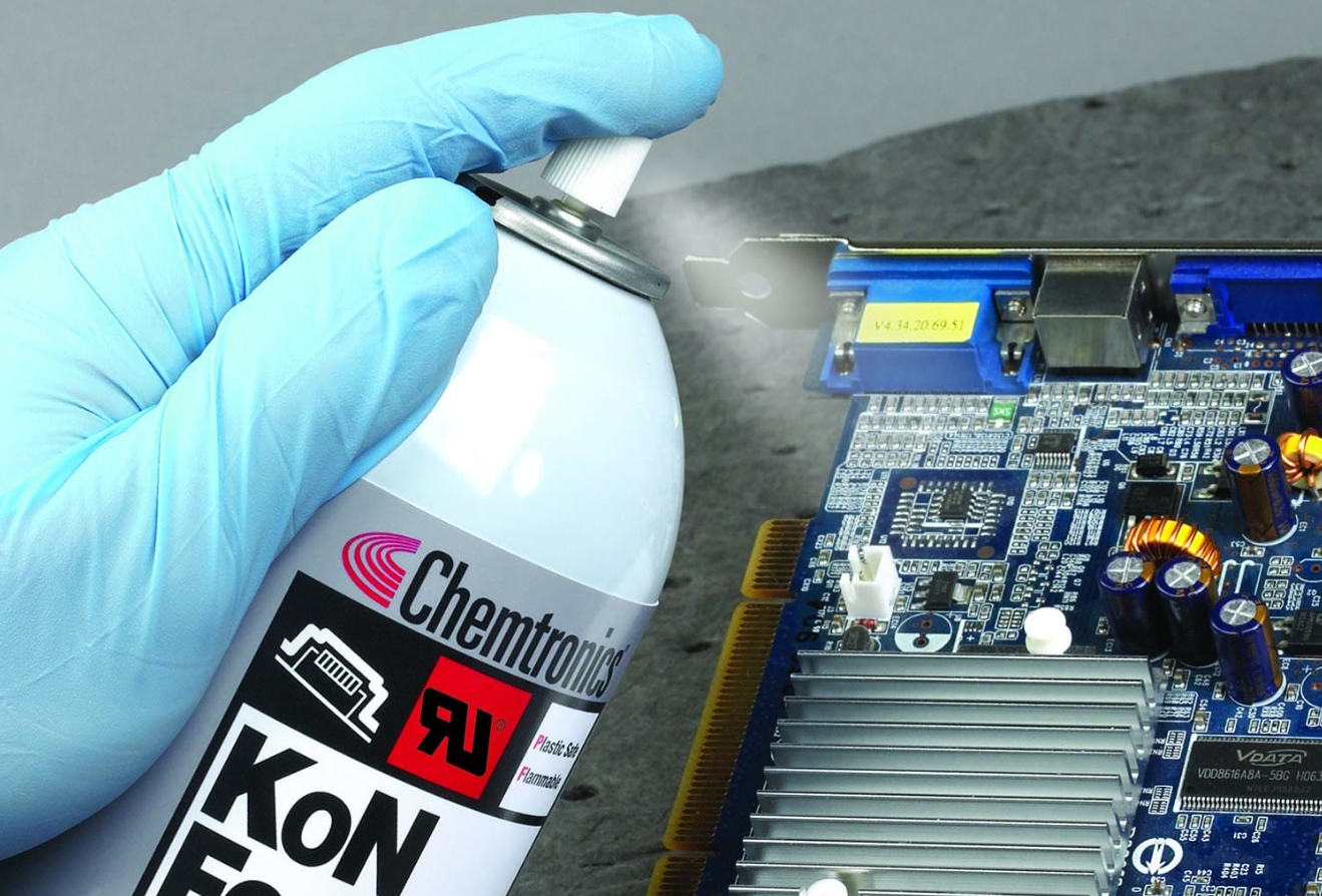 Spraying conformal coating on a PCB during reapplication process.