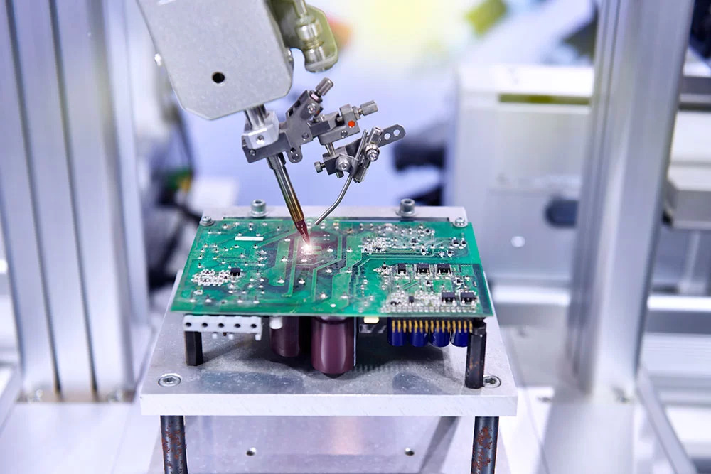 Laser drilling equipment creating micro-vias on a high-density PCB.
