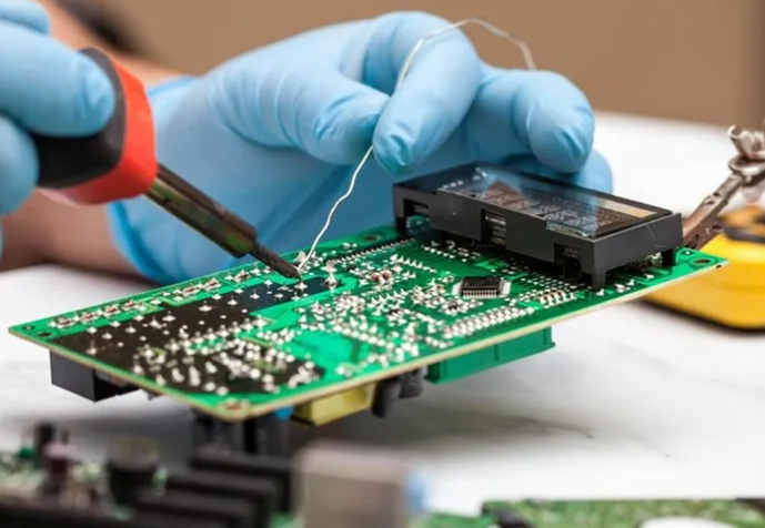 "Hand soldering a radial lead component on a PCB."