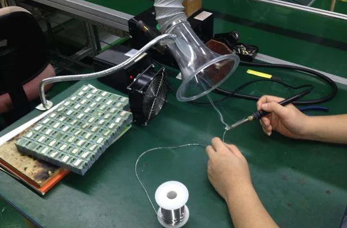 Worker soldering with fume extractor for soldering fumes safety