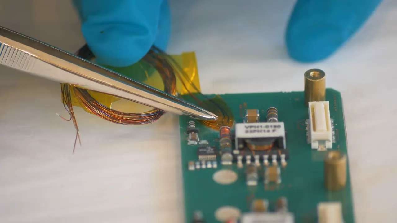 Testing a micro PCB prototype for functionality.