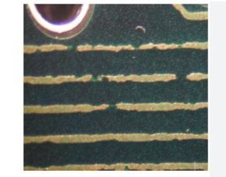 Close-up of fine line PCB traces showing etching defects