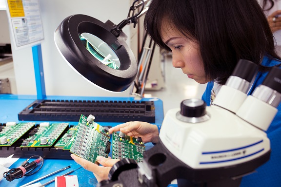 Inspecting SMD components on PCB with magnifying glass