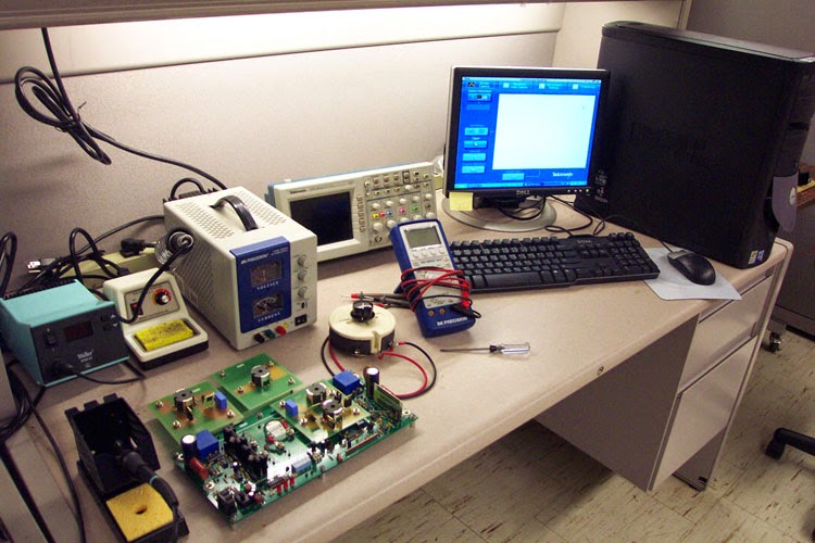 Workbench with tools for PCB troubleshooting and component testing."