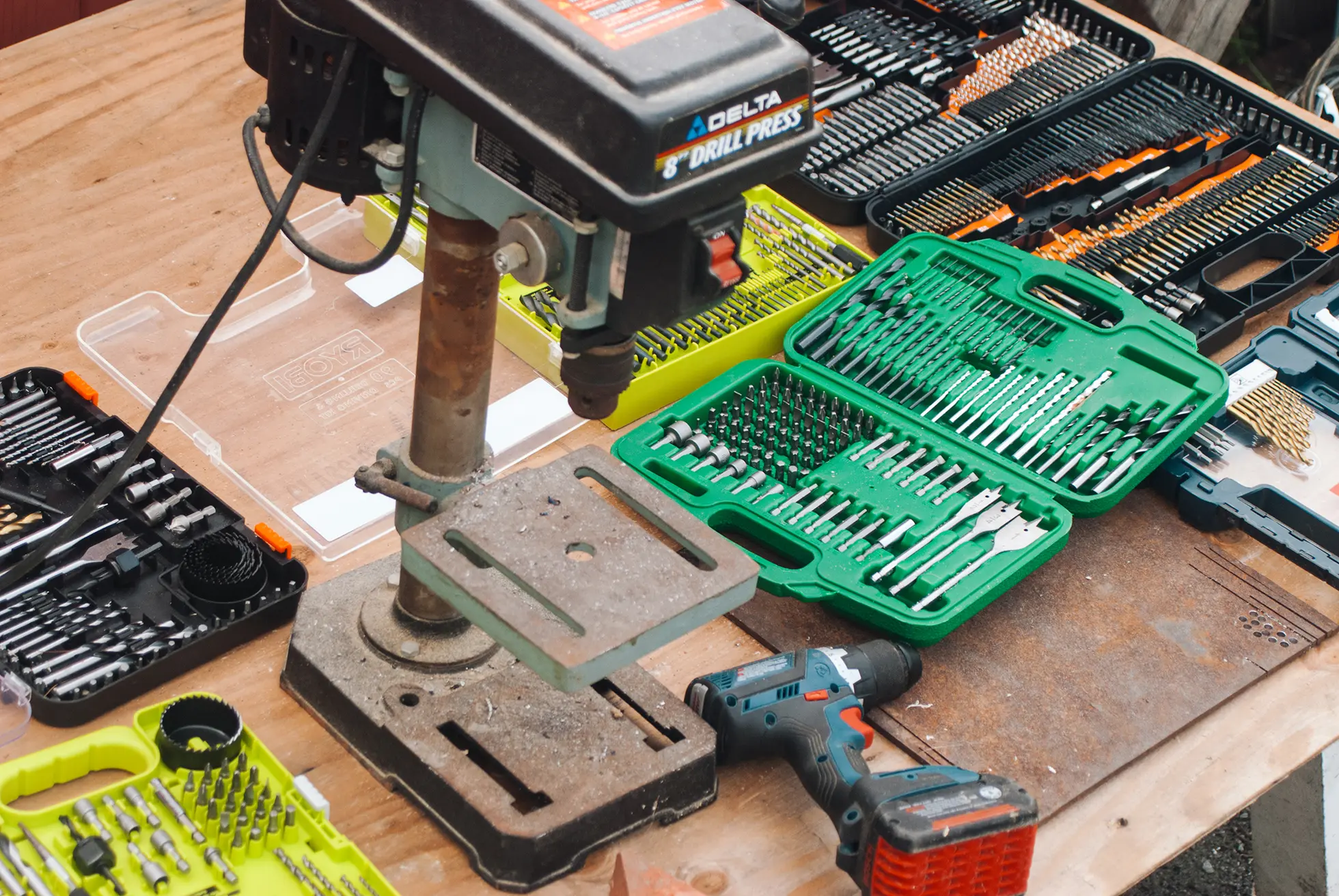 Essential PCB drilling tools for beginners including drill bits, hand drill, and safety gear.
