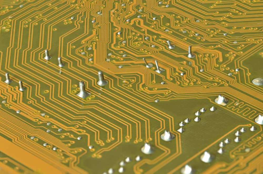 Close-up of flex PCB soldering defects including cold joints and bridges.