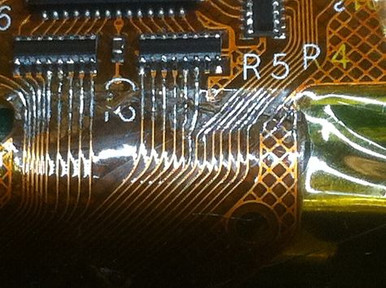 Technician performing rework on a flex PCB with a hot air station.