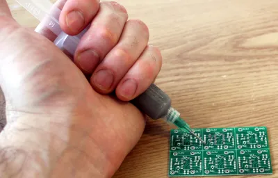 Applying solder paste with a syringe for SMD soldering."