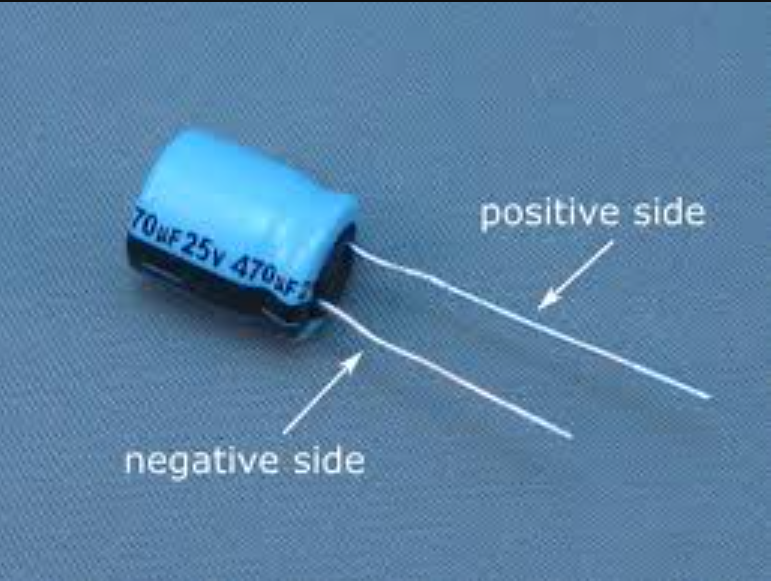 Electrolytic capacitor with polarity stripe and markings.
