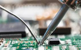 Hand soldering a through-hole component on an FR-4 PCB with a soldering iron