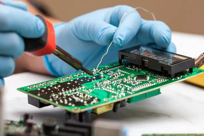 Hand soldering a through-hole component on a PCB
