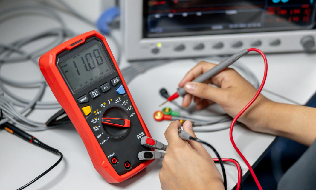 Testing a PCB with a multimeter for continuity and voltage.
